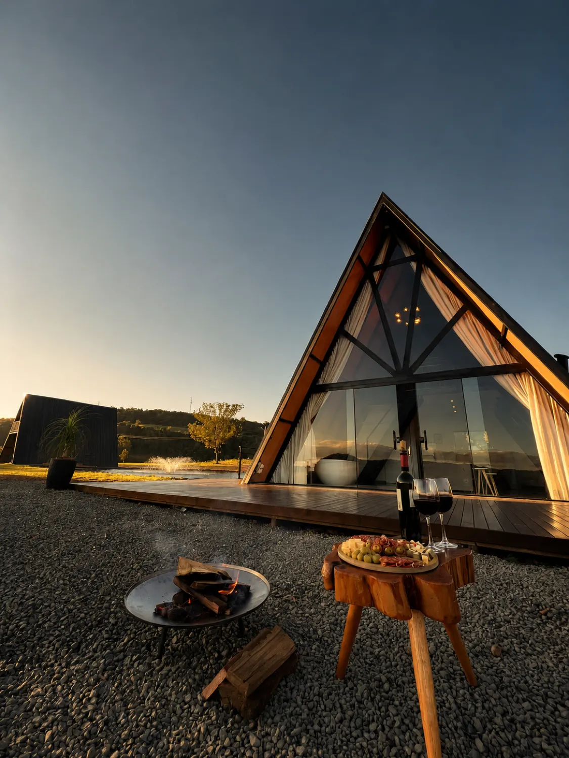 Chalé Refúgio em A ao pôr do sol, com mesa de vinho no deck