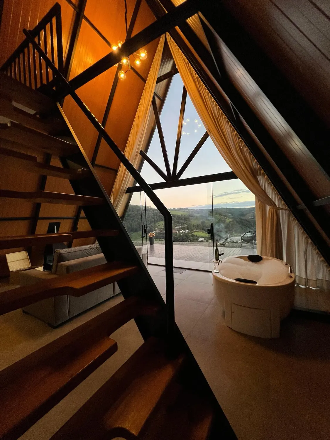 Sala do Chalé Refúgio com escada de madeira para o mezanino
